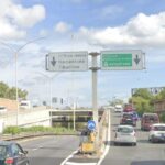 Svincolo della Tangenziale Est con cartelli “Nomentano–Tiburtino” e “GRA–autostrade”; traffico in coda su corsia destra, cielo nuvoloso.