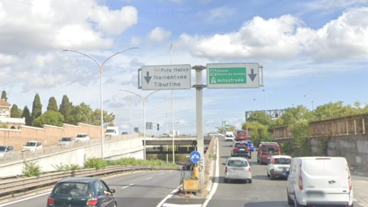 Svincolo della Tangenziale Est con cartelli “Nomentano–Tiburtino” e “GRA–autostrade”; traffico in coda su corsia destra, cielo nuvoloso.