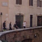 Parapetto curvo su via della Palombella accanto al Pantheon, con passanti davanti ai palazzi storici