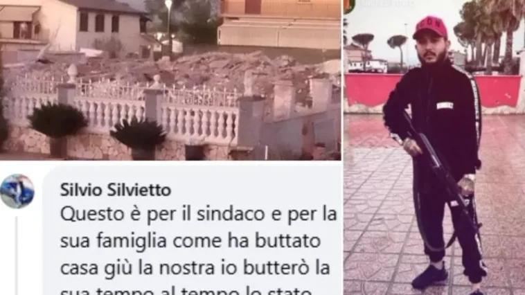 Collage con, a sinistra, una villetta crollata e detriti dietro una balaustra bianca; a destra un uomo in tuta nera e cappello rosso impugna un fucile. In basso si legge un commento che minaccia il sindaco di Roma dopo la demolizione di case abusive.