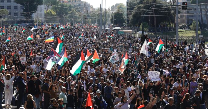 Folla numerosa a Roma con bandiere palestinesi e striscioni durante una manifestazione pro Palestina.