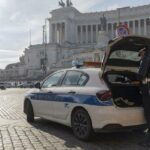 Agenti della Polizia Locale con auto di servizio mentre effettuano controlli a Piazza Venezia a Roma, davanti al Vittoriano