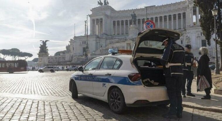 Agenti della Polizia Locale con auto di servizio mentre effettuano controlli a Piazza Venezia a Roma, davanti al Vittoriano