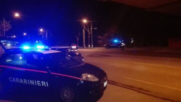 Pattuglie dei carabinieri con lampeggianti accesi durante un intervento notturno in una strada