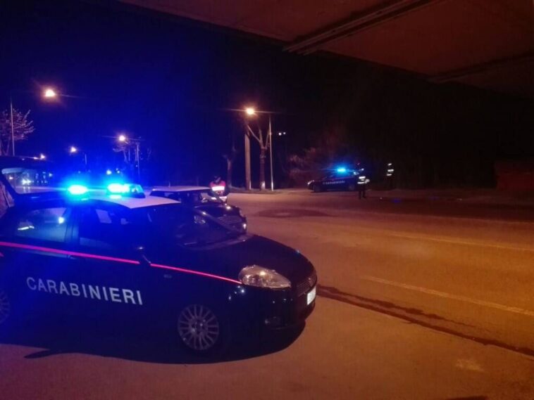 Pattuglie dei carabinieri con lampeggianti accesi durante un intervento notturno in una strada