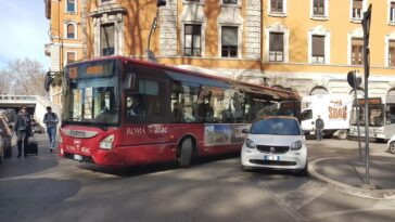 Autobus Atac 628 fermo in strada a causa di un’auto in sosta irregolare che impedisce il passaggio, in una via trafficata di Roma.