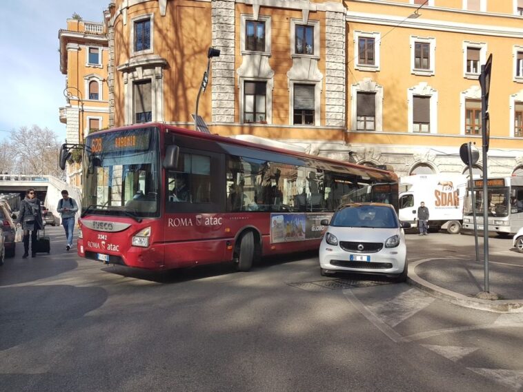 Autobus Atac 628 fermo in strada a causa di un’auto in sosta irregolare che impedisce il passaggio, in una via trafficata di Roma.