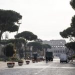 Vista dei Fori Imperiali chiusi al traffico con operai e mezzi al lavoro, Colosseo sullo sfondo.