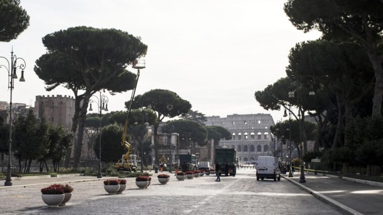 Vista dei Fori Imperiali chiusi al traffico con operai e mezzi al lavoro, Colosseo sullo sfondo.