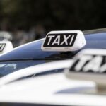Tetti delle auto bianche con insegna “TAXI” durante una giornata di protesta a Roma