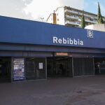 Ingresso esterno della stazione Rebibbia della metro B a Roma, con insegna blu e accessi pedonali.