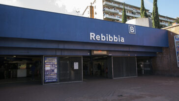 Ingresso esterno della stazione Rebibbia della metro B a Roma, con insegna blu e accessi pedonali.