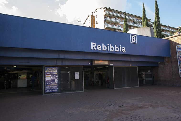 Ingresso esterno della stazione Rebibbia della metro B a Roma, con insegna blu e accessi pedonali.