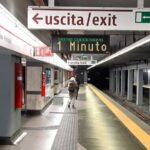 Banchina della metro A di Ottaviano con passeggeri e cartelli di uscita.