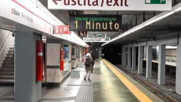 Banchina della metro A di Ottaviano con passeggeri e cartelli di uscita.
