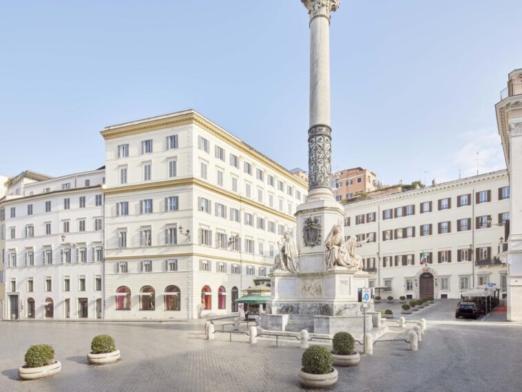 Vista di piazza Mignanelli a Roma con la Colonna dell’Immacolata e gli edifici storici circostanti in una giornata luminosa.