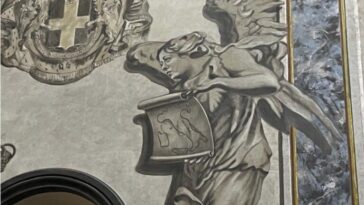 Affresco nella basilica di San Lorenzo in Lucina con un angelo dal volto umano che regge un cartiglio.