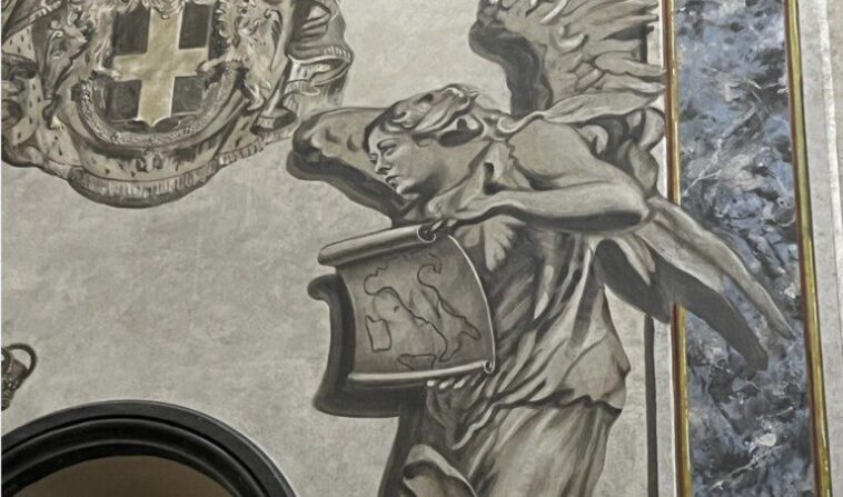 Affresco nella basilica di San Lorenzo in Lucina con un angelo dal volto umano che regge un cartiglio.