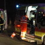 Ambulanze del 118 in intervento notturno con operatori sanitari attivi intorno ai mezzi di soccorso.