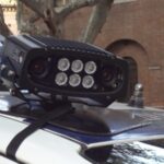 Dispositivo elettronico Street Control montato sul tetto di un'auto della polizia locale per il controllo automatico delle targhe.