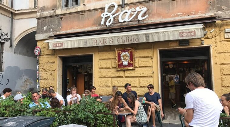 ingresso del Bar San Calisto a Trastevere con clienti seduti all’esterno.