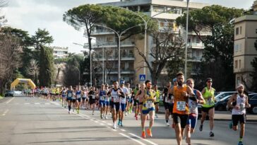 Atleti in corsa durante la Roma-Ostia su una strada chiusa al traffico.