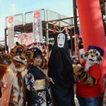 Gruppo di cosplayer e performer giapponesi ai Japan Days, tra kimono, mascotte e il personaggio Senza Volto.