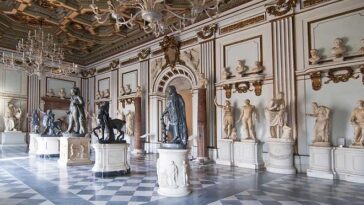 Sala monumentale con statue classiche e pavimento marmoreo nei Musei Capitolini.