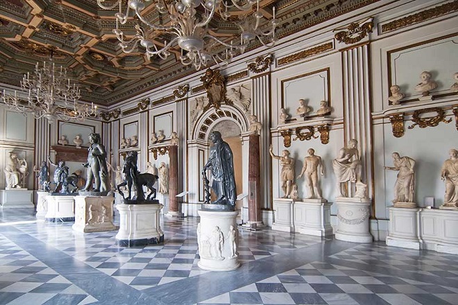 Sala monumentale con statue classiche e pavimento marmoreo nei Musei Capitolini.