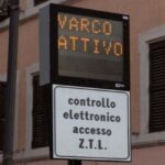 Cartello ZTL con scritta “Varco Attivo” su sfondo di palazzi nel centro di Roma.