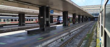 Binari e treni alla stazione ferroviaria di Roma Tiburtina con convogli regionali e alta velocità fermi in stazione.