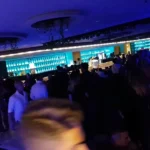 Interno del Divina Club a Roma con numerose persone ammassate vicino al bancone durante una serata in discoteca.
