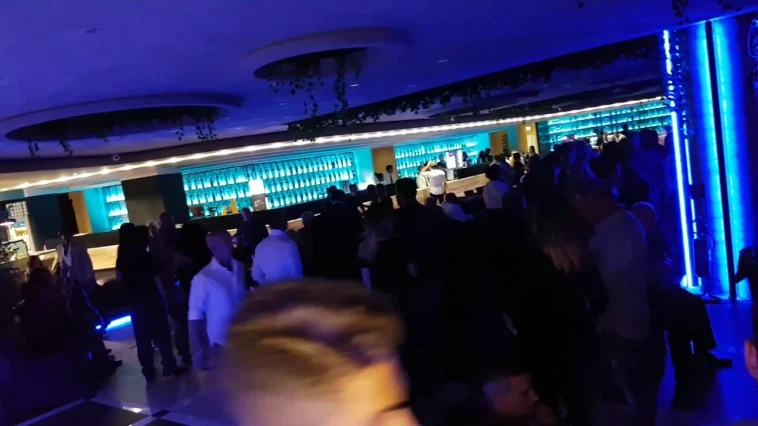 Interno del Divina Club a Roma con numerose persone ammassate vicino al bancone durante una serata in discoteca.
