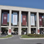 Ingresso monumentale dell’Università La Sapienza di Roma con colonne e banner ufficiali.