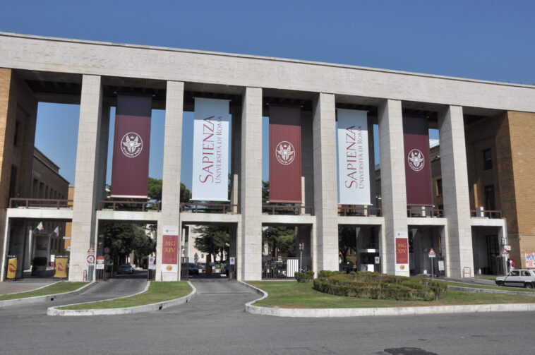 Ingresso monumentale dell’Università La Sapienza di Roma con colonne e banner ufficiali.