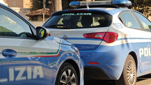 Auto della Polizia di Stato parcheggiate durante un intervento in strada a Roma.