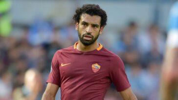 Mohamed Salah in campo con la maglia della Roma durante una partita, con espressione concentrata.