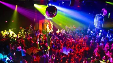 Discoteca affollata con luci colorate e pista da ballo piena di persone
