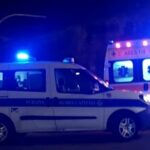 Auto della polizia locale e ambulanza intervenute di notte su un incidente stradale a Roma con luci di emergenza accese