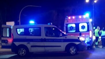 Auto della polizia locale e ambulanza intervenute di notte su un incidente stradale a Roma con luci di emergenza accese