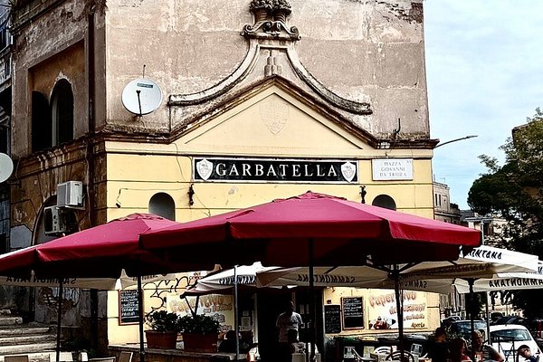 Il bar dei Cesaroni alla Garbatella con insegna storica e tavolini all’aperto in piazza Giovanni da Triora