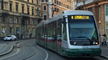 Tram in servizio nel centro di Roma lungo i binari tra palazzi storici e strade urbane trafficate.