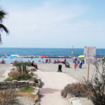 Spiaggia di Ostia con persone, ombrelloni colorati e mare sullo sfondo