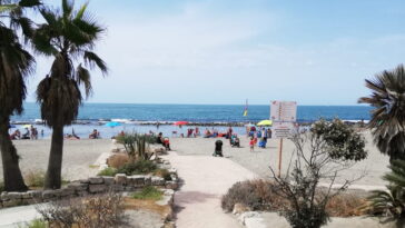 Spiaggia di Ostia con persone, ombrelloni colorati e mare sullo sfondo