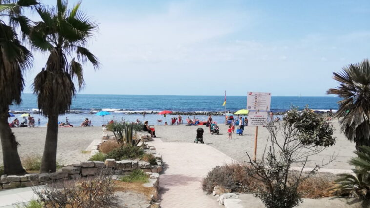 Spiaggia di Ostia con persone, ombrelloni colorati e mare sullo sfondo