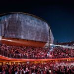 Concerto live all’Auditorium Parco della Musica con grande folla e palco illuminato