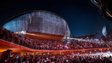 Concerto live all’Auditorium Parco della Musica con grande folla e palco illuminato