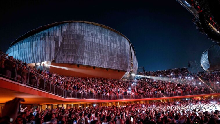Concerto live all’Auditorium Parco della Musica con grande folla e palco illuminato