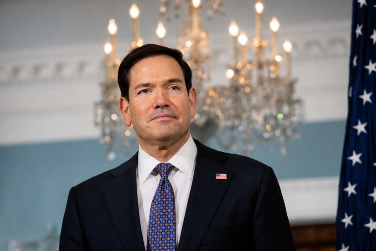 Marco Rubio durante un evento ufficiale con bandiera americana sullo sfondo