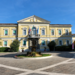 Facciata principale dell’ospedale Spallanzani di Roma con cortile centrale, fontana e cielo sereno.